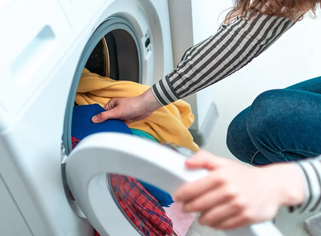 parent laundering clothes after being notified that their kid has lice