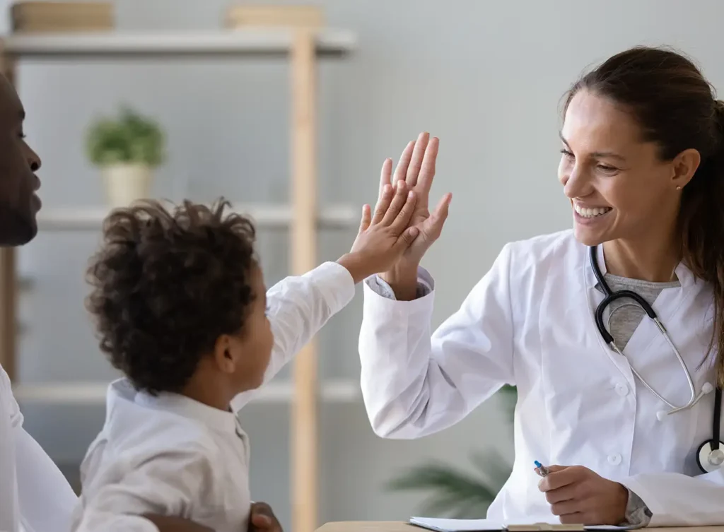 female lice health professional high fiving a young boy