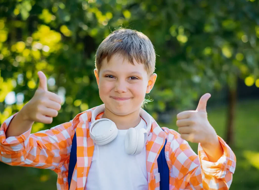 school-aged boy with his thumbs up
